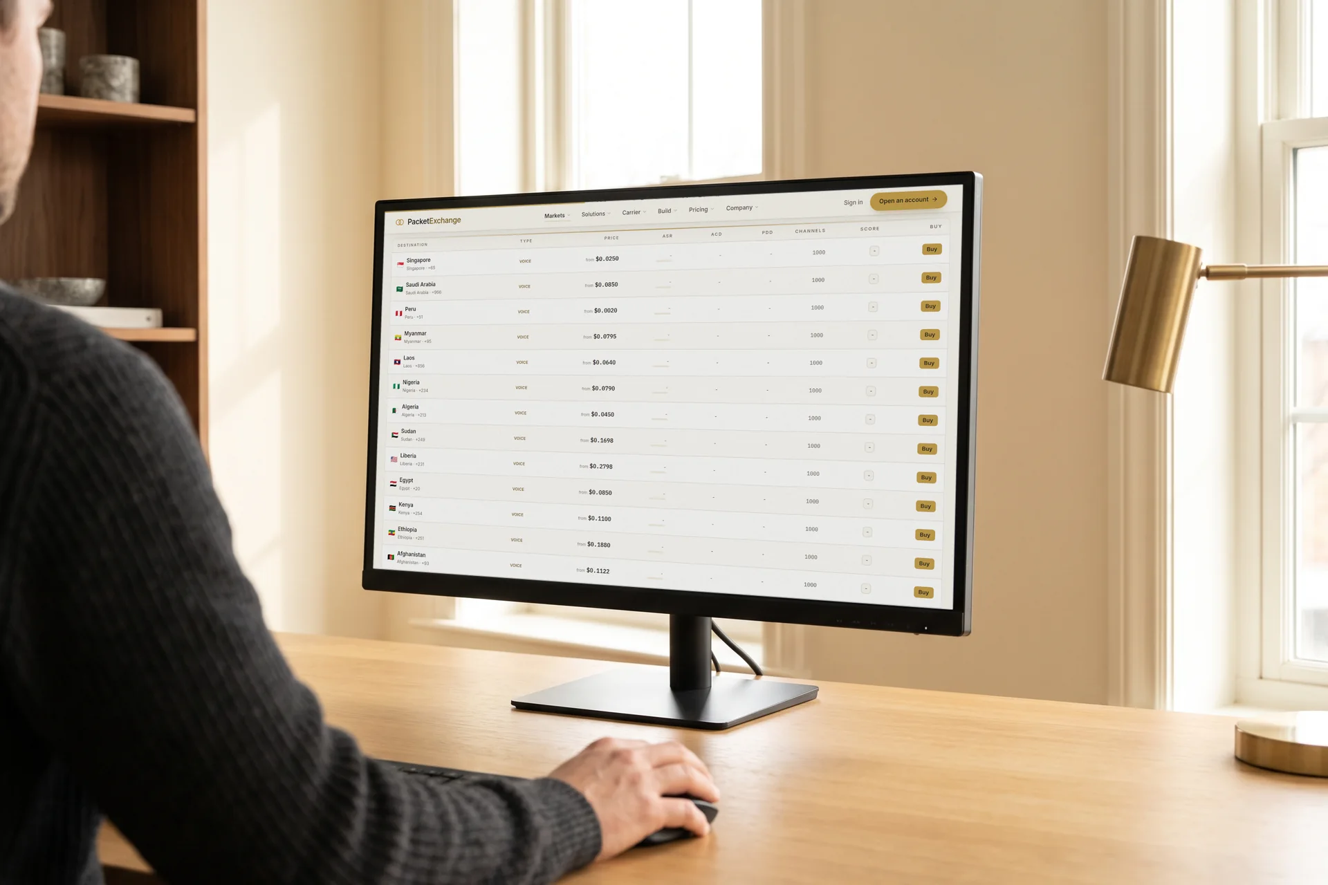 A developer at a desk with the PacketExchange marketplace route table open on a large monitor
